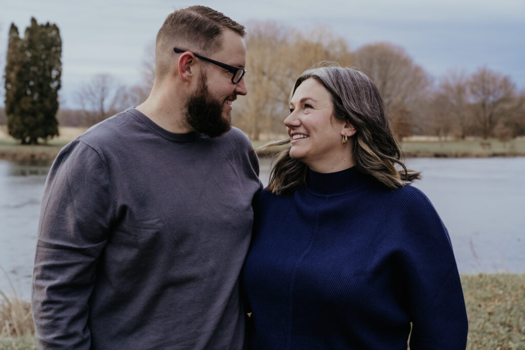 photo of a couple holding each other in front of a lake