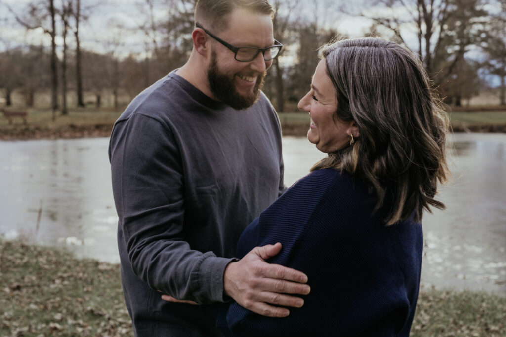 photo of a couple holding hands in front of a lake