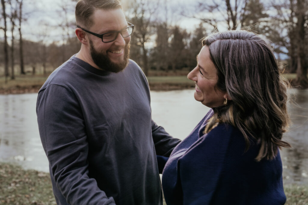 photo of a couple holding hands in front of a lake
